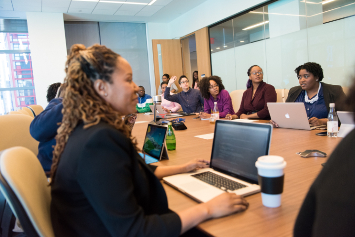 picture of diverse people sitting around a conference table making decisions.